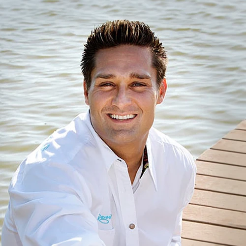 Chiropractor Christopher Hood sitting on doc by the water in St Petersburg FL